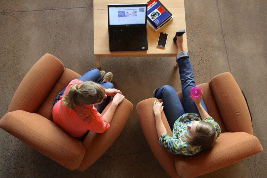 Two students chatting over a laptop