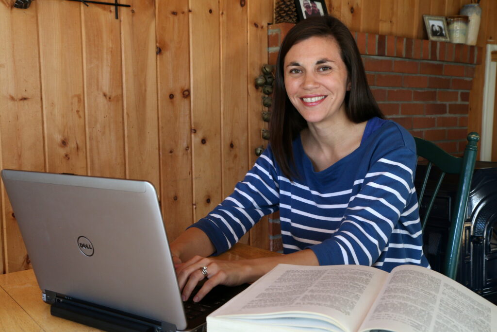 Student smiling and using laptop