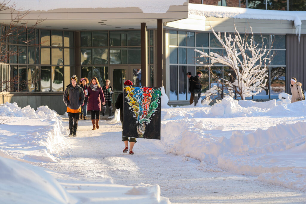 Students walking outside Swenson Hall in the snow