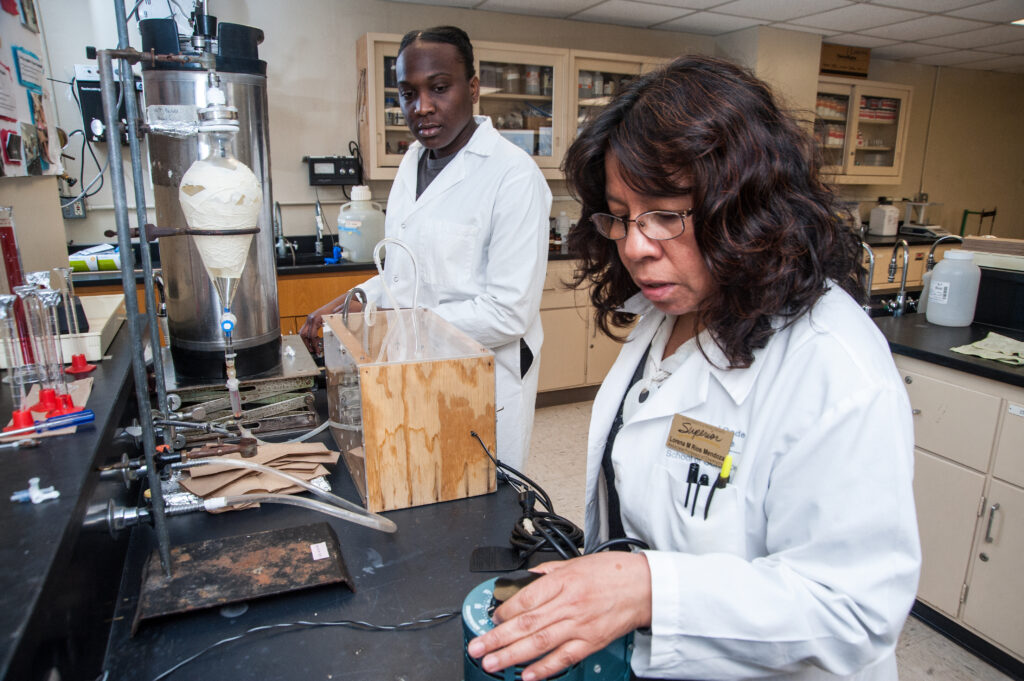 Two students in lab coats conducting an experiment