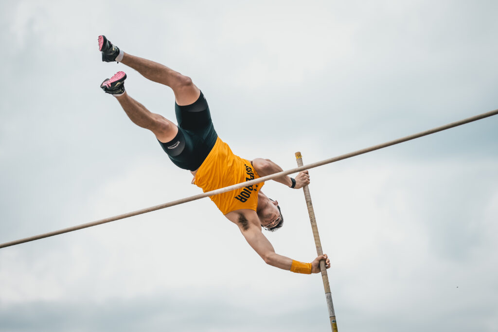 Men's track and field athlete doing a high jump.