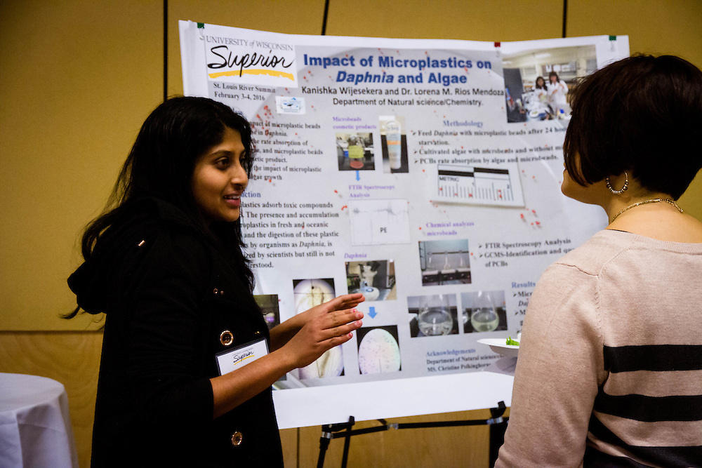 Student in front of diorama explaining Impact of Microplastics on Daphnia and Algae