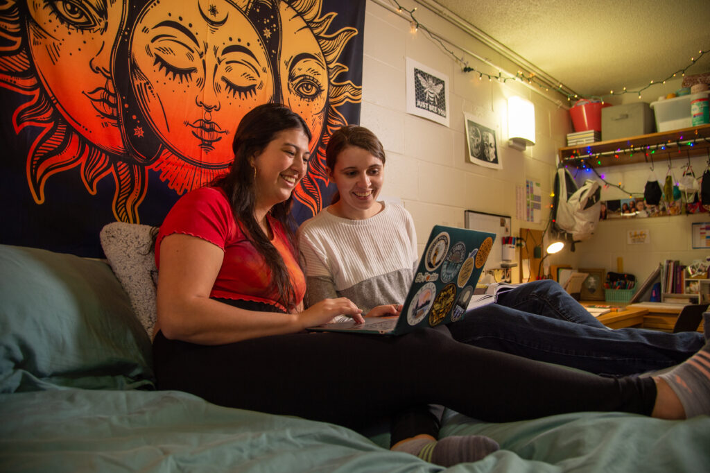 Students using laptop in a dorm room