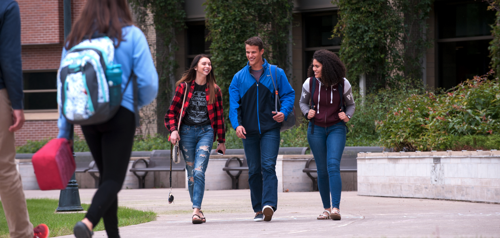 Three students walking across campus